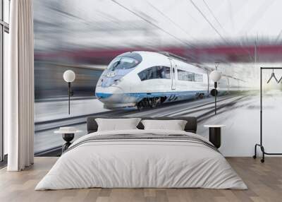 Train rides at high speed in winter around the snowy city industrial landscape Wall mural