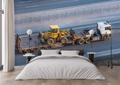 truck with a long trailer platform for transporting heavy machinery, loaded tractor with a bucket. h Wall mural