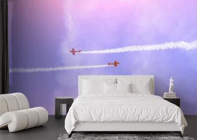 Two turboprop airplane with a trace of white smoke against a blue sky. Wall mural