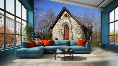 Historical old vintage abandoned mini stone church stands enclosed around a forest out in the countryside Wall mural