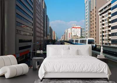 View of a train traveling on elevated tracks of Taipei Metro System between office towers under blue clear sky ~ View of MRT railways in Taipei, the capital city of Taiwan, on a beautiful sunny day Wall mural