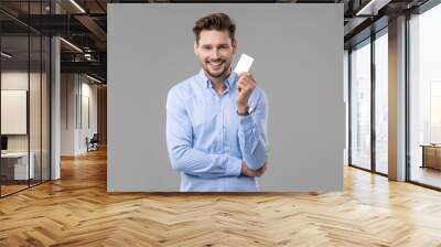 Handsome man in blue shirt  with white card Wall mural