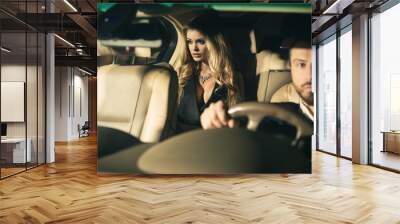 Sexy couple in the car. Focus on woman Wall mural