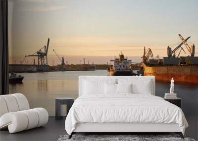 Large cargo ship loading in port terminal. Sunset. Freight transportation, nautical vessel, logistics, global communications, worldwide shipping, economy, business, industry Wall mural