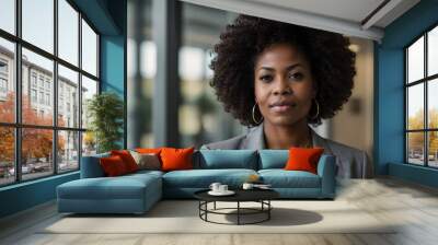 portrait of a black woman with an afro hairstyle standing by a window in an office	 Wall mural