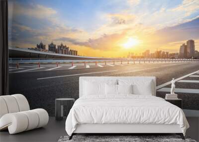 Asphalt highway road and city skyline with modern buildings at sunset. car background. Wall mural