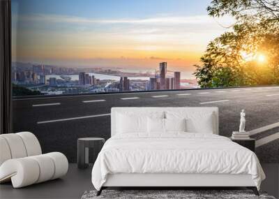 Asphalt highway road and skyline with modern buildings at sunset Wall mural