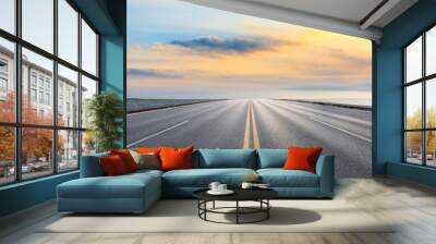 Asphalt road and dramatic sky with coastline at sunset Wall mural