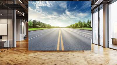 Asphalt road and green forest landscape under the blue sky Wall mural