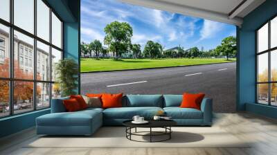 Asphalt road and green trees with grass background Wall mural