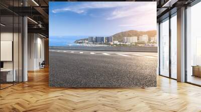 Asphalt road and modern city commercial buildings with skyline by the sea Wall mural