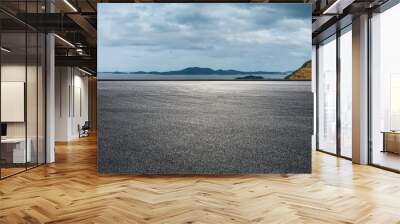 Asphalt road and mountain with sea natural landscape on a cloudy day Wall mural