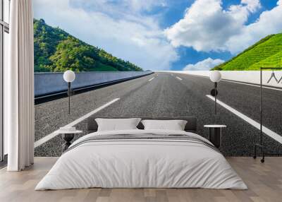 Asphalt road and mountain with tea plantation under blue sky.Road and mountain background. Wall mural