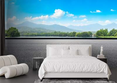 Asphalt road and mountains with white clouds Wall mural