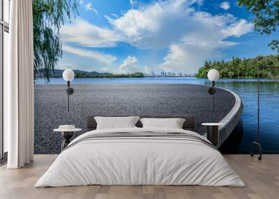 Asphalt road platform and lake with city skyline background Wall mural