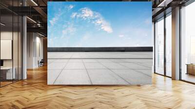 Clean square floor and blue sky with white clouds Wall mural