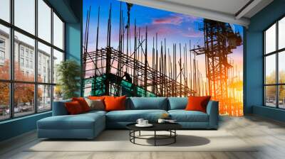 Construction site with crane and workers at sunset Wall mural