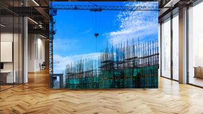 Crane and building construction site against blue sky. Wall mural