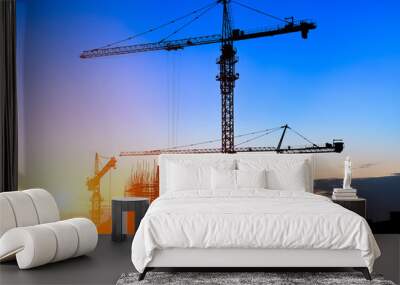 Crane and building construction site at sunset Wall mural