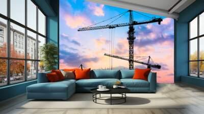 Crane and building construction site at sunset Wall mural