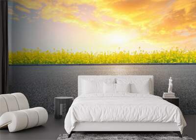 Empty asphalt road and blooming rape flowers in farmland field. Wall mural