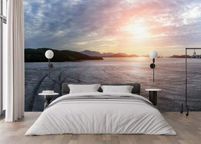 Empty asphalt road by the sea. Road and mountain with sea at sunset. Wall mural