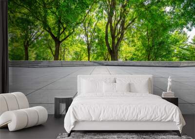 Empty square floor and green forest in city park. Wall mural