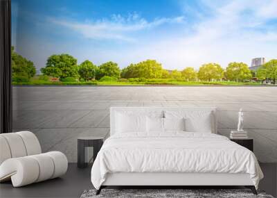 Empty square floor and green trees under blue sky Wall mural