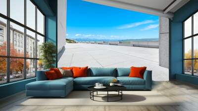 Empty square floor and mountains under blue sky Wall mural