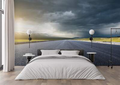 Straight asphalt highway road and mountain nature background at sunset Wall mural