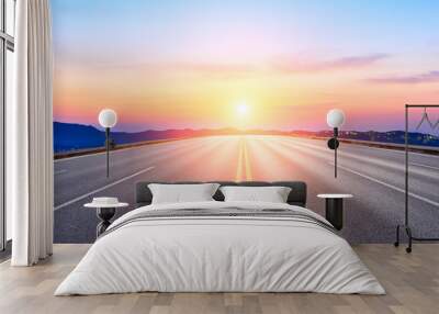 Straight asphalt road and beautiful mountain nature landscape at sunset Wall mural