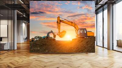 Three excavators work on construction site at sunset Wall mural