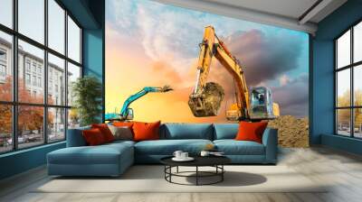 Two excavators work on construction site at sunset Wall mural