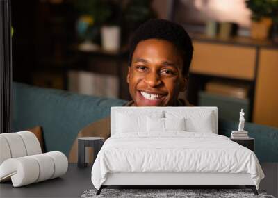 Portrait of beaming smile and infectious joy of an African man who looks directly into the camera welcoming expression invites the viewer in, while his eyes twinkle with happiness and optimism Wall mural