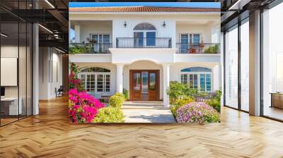 white-walled cottage facing a tiny garden full of flowers and plants in the full blue sky and sunshine Wall mural