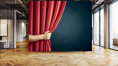 Hand pulls open vibrant red curtain against dark background, stage setting For Social Media Post Size Wall mural