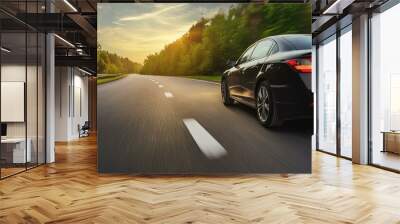 A black car is driving down the street at high speed. Wall mural