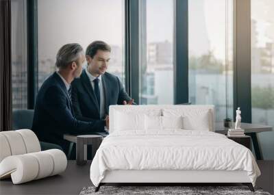 two coworkers discussing business details while sitting in modern office space Wall mural