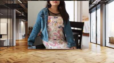 Indian Bengali beautiful and cute brunette girl in a casual blue jeans shirt and white top is sitting on the dinning table in a casual way inside a room. Indian lifestyle and fashion portrait Wall mural