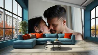 Indian Bengali beautiful brunette couple sharing intimate romantic moments standing in front of a window in white background. Indian lifestyle  and romantic couple Wall mural