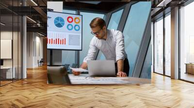 Young attractive businessman working with laptop Wall mural