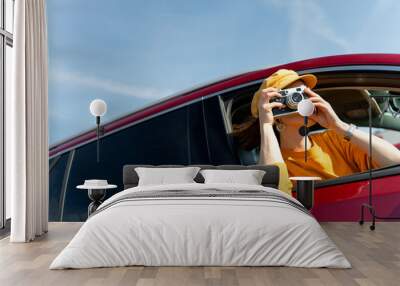 Young girl taking photos in the red car Wall mural