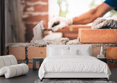 bricklayer worker installing brick masonry on exterior wall with trowel putty knife Wall mural