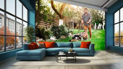 Close up details of landscaping and gardening. Worker using industrial manual lawnmower. Wall mural