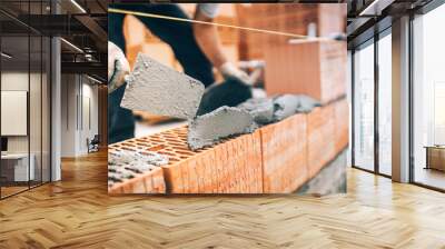 close up of construction worker details, protective gear and trowel with mortar building brick walls Wall mural