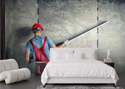 industrial worker with plastering tools renovating a house. builder worker plastering facade industrial building with leveler Wall mural