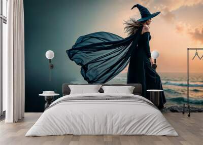 Halloween. Beautiful young witch conjures on Halloween on the seashore Wall mural