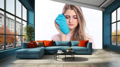 Woman holding icepack against her cheek Wall mural