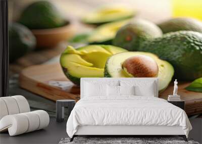 Close up of sliced and halved fresh avocados on a cutting board with avocado in the background Wall mural