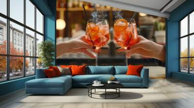 Aperol spritz cocktail glasses in hands of couple toasting, with black smoking straw on bar counter, closeup shot, focus depth of field effect, background is modern minimalistic cafe interior Wall mural